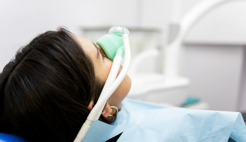 Patientin liegt im Behandlungsstuhl und erh&auml;lt Lachgas &uuml;ber eine Nasenmaske zur entspannteren Zahnbehandlung
